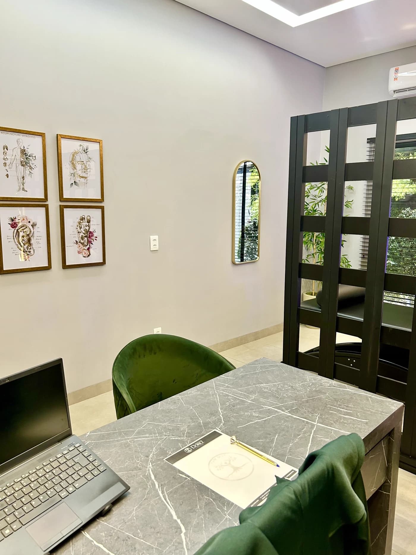 Sala de atendimento com os mapas de acupuntura na parede